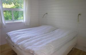 a white bed in a room with a window at Holiday Home Sahara Rønne I in Hasle +6 photos