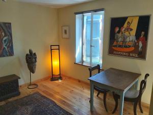 a living room with a table and a lamp at Brocante Heaven 1 in Aignan