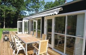 a screened in deck with a table and chairs at Holiday Home Sahara Rønne I in Hasle