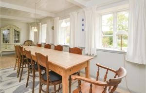 SønderhoにあるStunning Home In Fan With 3 Bedrooms, Sauna And Wifiのダイニングルーム(木製テーブル、椅子付)