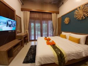 a bedroom with a large bed with a flat screen tv at Thap Kaek B2 Villa in Klong Muang Beach