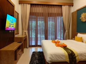 a hotel room with a bed and a television at Thap Kaek B2 Villa in Klong Muang Beach