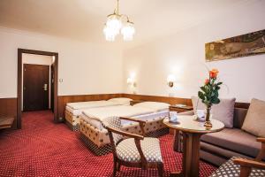 ein Hotelzimmer mit einem Bett und einem Sofa in der Unterkunft Hotel Ostrov in Nymburk