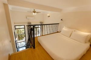 a bedroom with a white bed and a balcony at Mountain View Station in Sa Pa