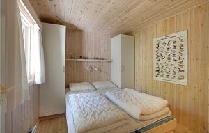 a bedroom with a bed in a wooden wall at Hubertus in Spidsegård