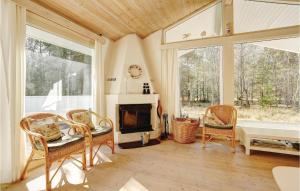 a living room with a fireplace and a table and chairs at Hubertus in Spidsegård +9 photos