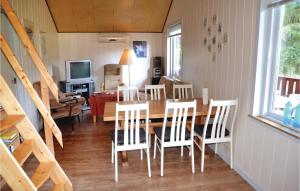 a dining room and living room with a table and chairs at 3 Bedroom Lovely Home In Tarm in Hoven