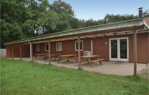 a cabin with picnic tables in front of it at Amazing Home In Tarm With 3 Bedrooms in Hoven