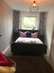 a bedroom with a bed with pink pillows and a window at Komfort Ferienwohnung à la Bella in Mechernich