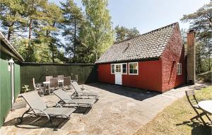un patio avec des chaises et un petit bâtiment rouge dans l'établissement Finkereden, à Bedegård