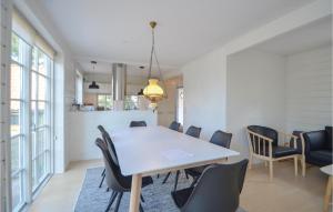 a dining room with a white table and chairs at Two-Bedroom Holiday Home In Ebeltoft in Ebeltoft +18 photos