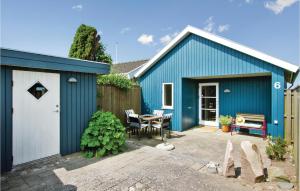 a blue house with a table and a fence at Holiday Home Ny Bamsestræde O-624 in Otterup