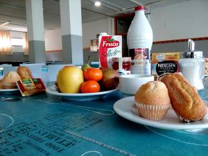 a table with plates of food and muffins on it at Residencia Albergue Jaca in Jaca