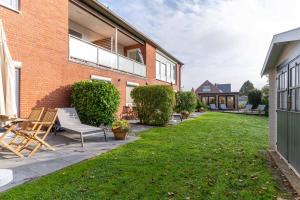 a patio with chairs and a lawn in front of a building at Diekhuus Büsum in Büsum