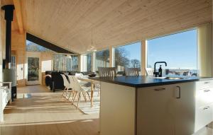 cocina y sala de estar con barra y sillas en Awesome Home In Haderslev With 4 Bedrooms, Sauna And Wifi, en Haderslev