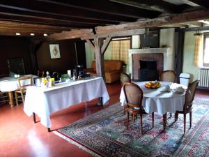 a dining room with two tables and chairs and a fireplace at Domaine de la Richardelle in Courtenay