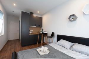 a bedroom with a bed and a small kitchen at Oak house apartments in Kaunas