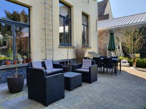 un patio con sofás, sillas y una mesa. en Erasmus Hotel en Ghent