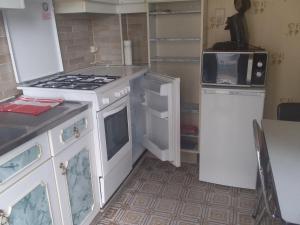 a small kitchen with a stove and a refrigerator at Charlierhelling app 22 in Blankenberge
