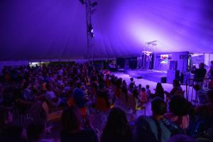a crowd of people watching a stage in a tent at Villaggio Orizzonte in Riotorto +85 photos