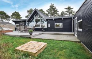 a backyard with a black house with a deck at Amazing Home In Ebeltoft With 4 Bedrooms And Wifi in Ebeltoft