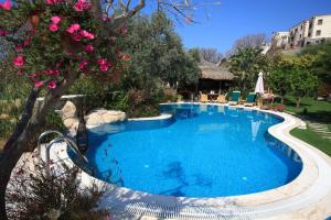 una gran piscina en un patio con flores en Sandima 37 Suites Hotel, en Yalıkavak