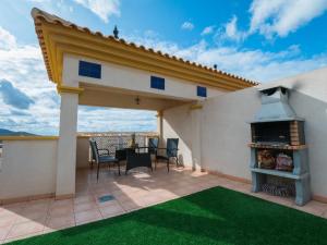a patio with a table and a fireplace on a roof at Apartament Sofia in Mar de Cristal