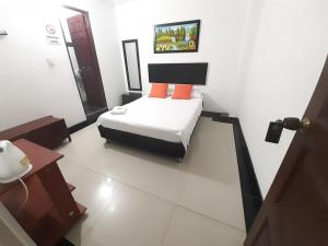 ein kleines Zimmer mit einem Bett in einem Zimmer in der Unterkunft Hotel Arcoiris Girardot in Girardot