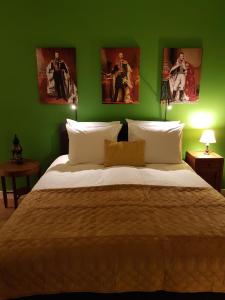 a bedroom with a green wall with a large bed at Emma's B&B in The Hague