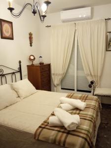 1 dormitorio con 2 camas con almohadas blancas y ventana en Alojamiento OliCazorla, en Cazorla