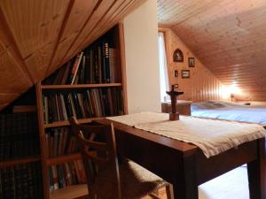 a bedroom with a bed and a desk and bookshelves at Agriturismo Bosco Di Museis in Cercivento