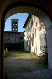 une arche menant à un bâtiment avec une tour d'horloge dans l'établissement Garibaldi residence in Rieti, à Rieti