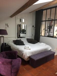 a bedroom with a large bed and a chair at Loft avec spa Lourmarin in Lourmarin