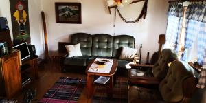 sala de estar con sofá de cuero y mesa en Drevenica pod Tlstou en Blatnica