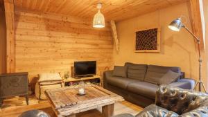 a living room with a couch and a tv at Chalet Le Villarais in Villard-Reculas