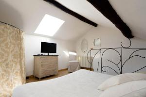 Dormitorio con cama y tocador con TV en Pin de stèlle, en San Martino