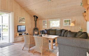 a living room with a couch and a table and a fireplace at Awesome Home In Oksbl With Wifi in Oksbøl