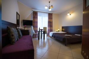 a bedroom with a bed and a couch in a room at Villa BALTICA in Rowy