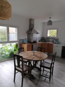 cocina con mesa de madera y sillas en una habitación en Le Grenier de Gaston, en Thouars-sur-Garonne