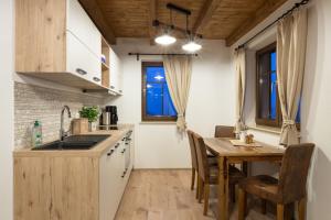a kitchen and dining room with a wooden table and chairs at Haus Waldfrieden in Kurort Altenberg