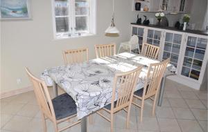uma mesa de jantar com cadeiras e uma toalha de mesa com flores em Beautiful Home In Sydals With Wifi em Skovby
