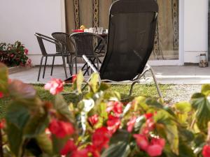 a chair sitting next to a table and some flowers at D&N Apartment in Ljubljana