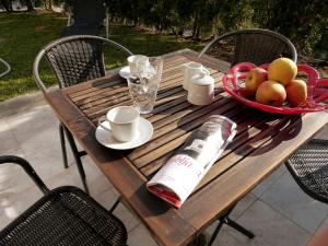a wooden table with a bowl of fruit and a bottle of wine at D&N Apartment in Ljubljana