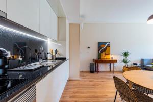 een keuken met zwarte aanrechtbladen en een tafel bij Boavista Garden Apartment in Porto