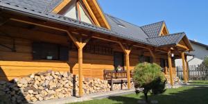 a wooden house with a pile of fire wood at Drevenica pod Tlstou in Blatnica