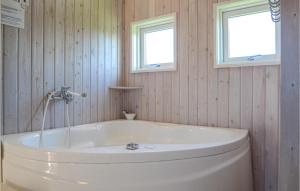 a white tub in a bathroom with two windows at Holiday Home Søndervang Hejls in Hejls