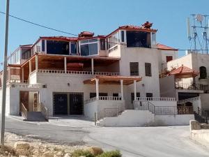 Una gran casa blanca con un porche encima. en Basant Villa, en Wadi Musa