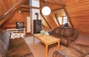 a living room with leather furniture and a wood stove at Stunning Home In Haderslev With Kitchen in Haderslev