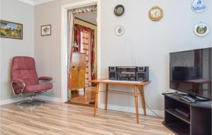 a living room with a television and a chair at 2 Bedroom Cozy Home In Gamleby in Gamleby