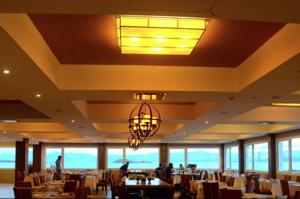 Hotel Las Dunas في إل كالافاتي: غرفة طعام بها طاولات وكراسي وثريا